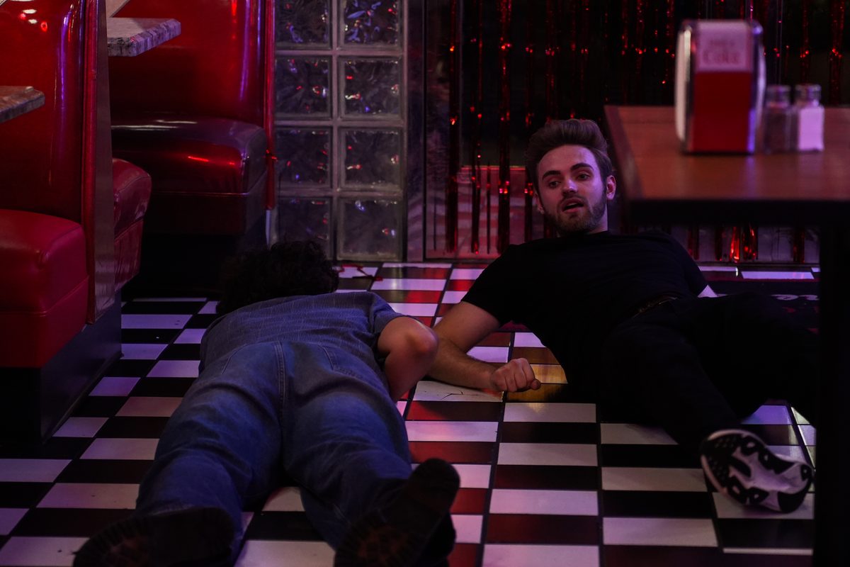 Lying on the checkered diner floor beside an actor to line up a shot