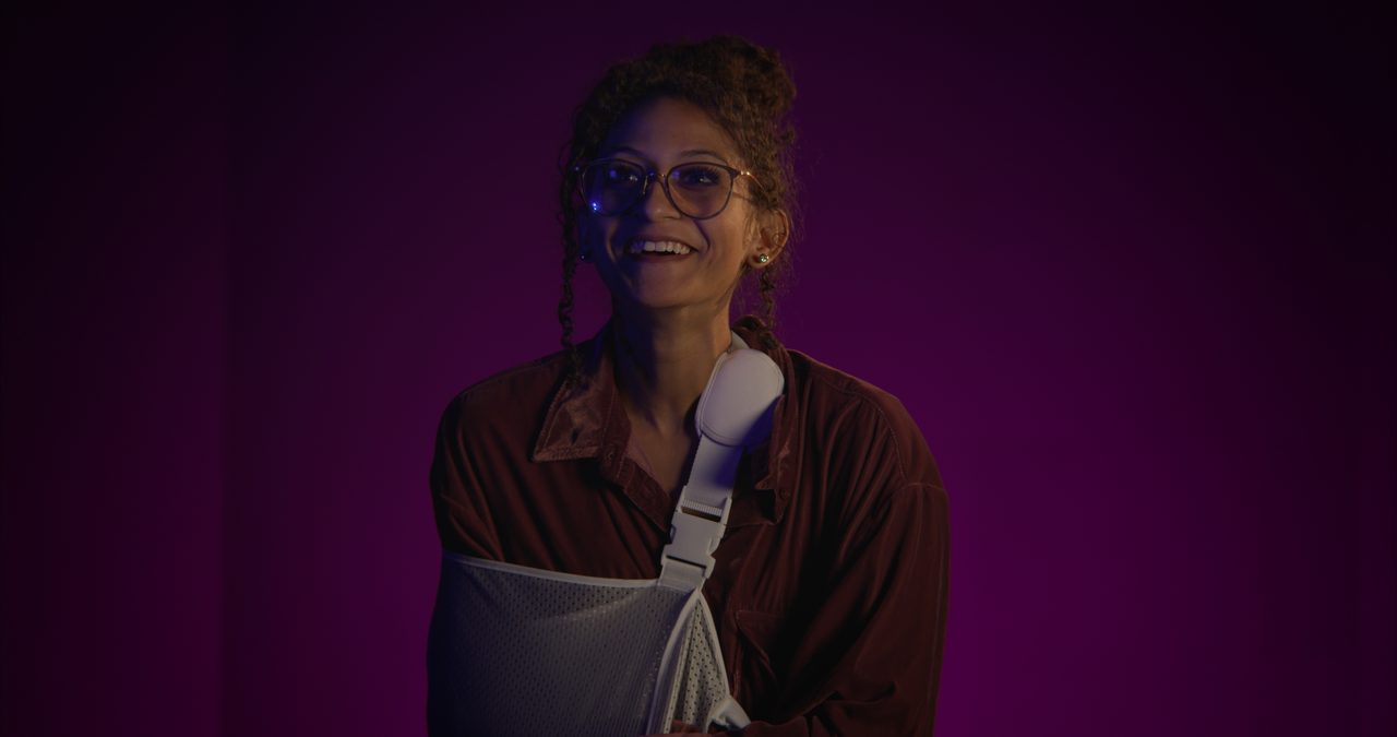 Joslyn laughing against a deep purple backdrop