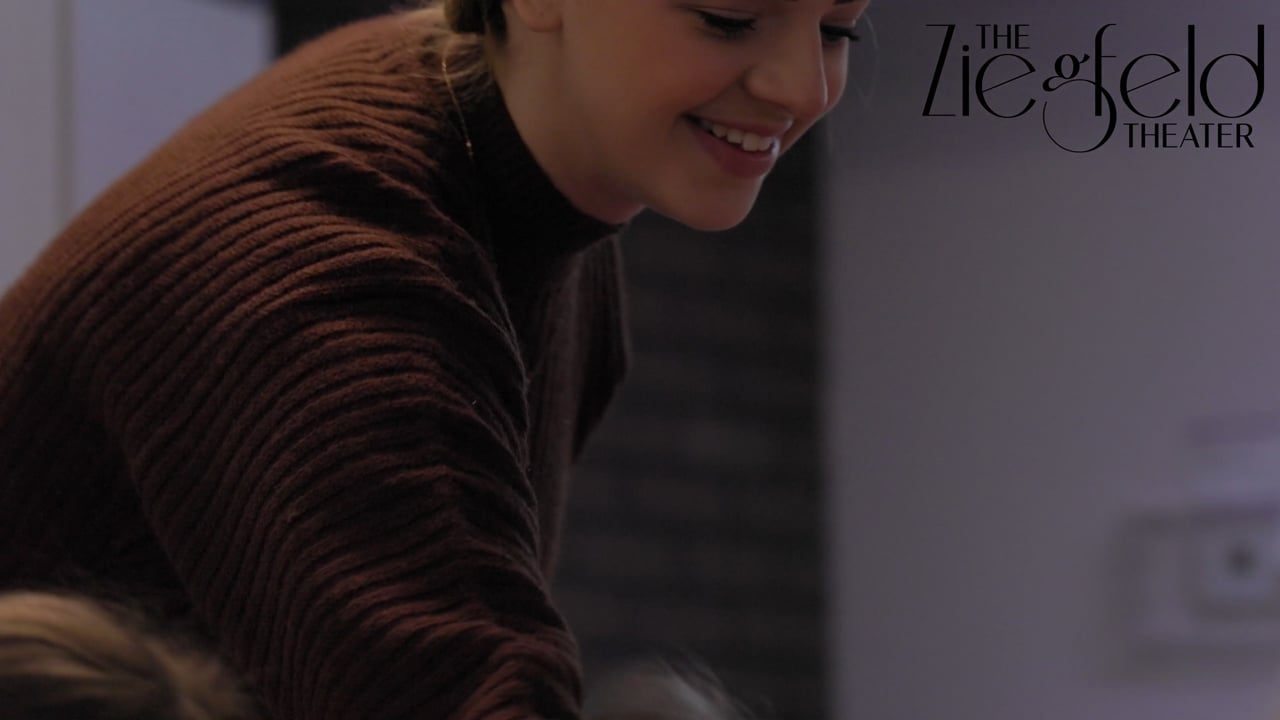 A woman smiling, looking down